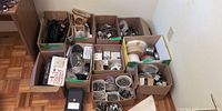 Overall view of nine boxes of assorted electrical and hardware items