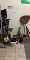 Group view showing power washer, shovels, brooms, boxed Weedex bar, planter and box of small tools