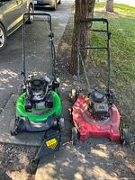 Green Lawn-Boy and red Tecumseh mowers side by side on driveway