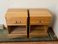 Front view of both night tables showing drawer, shelf and base design