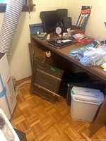Overall view of desk with shredder, cutting boards, briefcases and assorted office supplies
