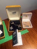 Keychain and necklace in their boxes with paperwork