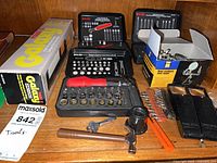 Shelf view showing Galaxy lamp box, two bit kit cases, magnifier box, hammer, orange tool, loose bits