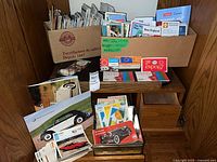 Overall view of two boxes filled with maps, brochures and car calendars