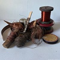 Overview of lot showing spooled and loose copper wire, wooden spool and cardboard Harden spool