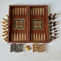 open board showing backgammon field, chess pieces, checkers and dice