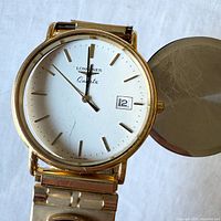 Front view showing dial, missing crystal, open caseback, bracelet