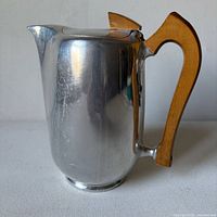 Right side view showing body, spout, wood handle and lid