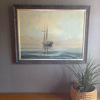 Framed sailboat oil painting on wall, full view