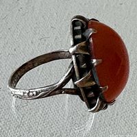 Side view of silver ring showing carnelian cabochon and ornate prong setting