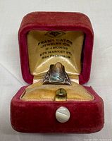 ring in open velvet box showing interior hallmark text