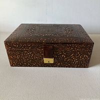 Front view showing embossed leather and brass latch