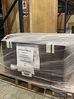 Plastic-wrapped espresso cabinet with shipping label on pallet