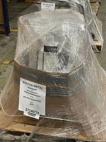 Pallet-wrapped bundle of silver metal desk legs with Boston Metal label showing lot number