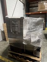 Entire white credenza wrapped on pallet with label visible