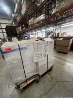 Pallet with wrapped cream tone cabinets in warehouse aisle