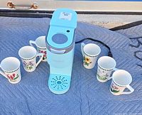 Full lot showing Keurig brewer surrounded by six floral mugs