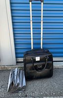 Suitcase standing with telescopic handle extended, organizer folded beside