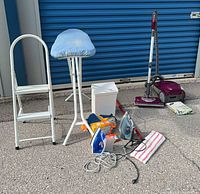 Group shot of entire lot showing ladder, ironing board, garbage can, irons, vacuum, vacuum head, dusting boxes and vacuum bags