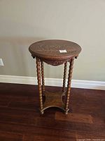 Full view of round wood table with spindle legs and lower shelf