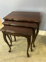 Three stacked wood nesting tables, side view