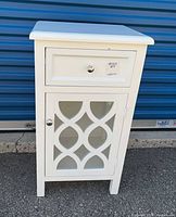 Front view of white side table showing drawer and cabinet door