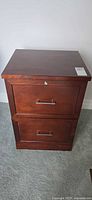 Front view of two-drawer wooden file cabinet with metal handles