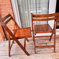 two wooden folding chairs, one folded, one standing