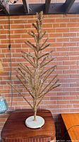 Full view of gold tinsel Christmas tree on table