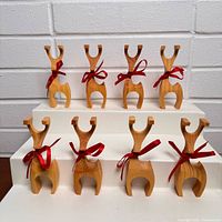 Front view of eight carved wood reindeer figurines