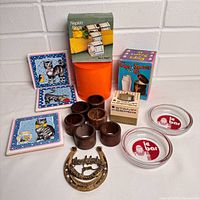 Group shot of all items including tiles, napkin rings, ashtrays, plaque, boxes and canister