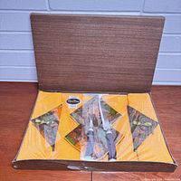 Set in opened box showing placemats, napkins and carving set