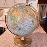 Front view of globe showing Africa, Europe, Asia on gold-tone stand