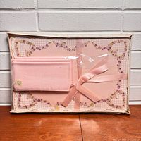 Front view of sealed boxed pink placemat and napkin set
