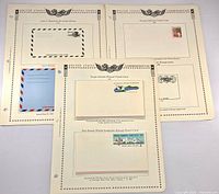 Three album pages displaying five postal stationery items