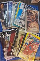 Stack of approximately 30 bagged and boarded comics showing mixed titles; Buffy, Superman, Spider-Man, Saga visible