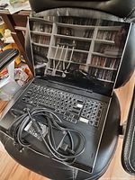 Alienware M17x laptop open on chair with power adapter