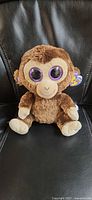 Front view of Ty Coconut Beanie Boo plush seated on chair