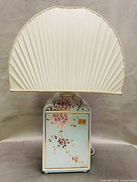 Front view of lamp showing floral design, shade, and overall appearance