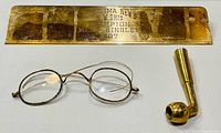 Front view of plaque, eyeglasses and pipe