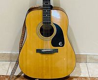 Front view of Epiphone DR-100 guitar with strap