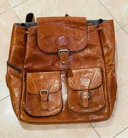 Front view showing leather, flap, two front pockets