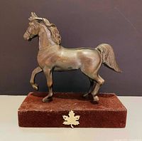 Front left view of cast metal horse on stone base