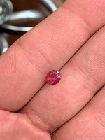 Ruby resting on fingertip showing size and cut