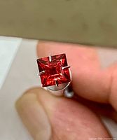 Front view of square princess-cut rhodolite garnet held in holder