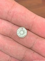 Front of jadeite Bagua pendant showing carved trigrams and drilled hole