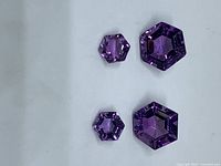 Four hexagon-cut amethyst gemstones grouped