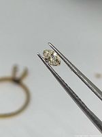Diamond held in tweezers displaying marquise shape and sparkle