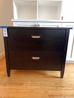 Front view of black-brown 2-drawer chest showing handles and finish