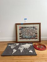 Group shot showing framed Cambridge map, rolled gray world map, and red round tray